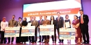Winners posing with their mock cheques and certificates with VIPs on stage